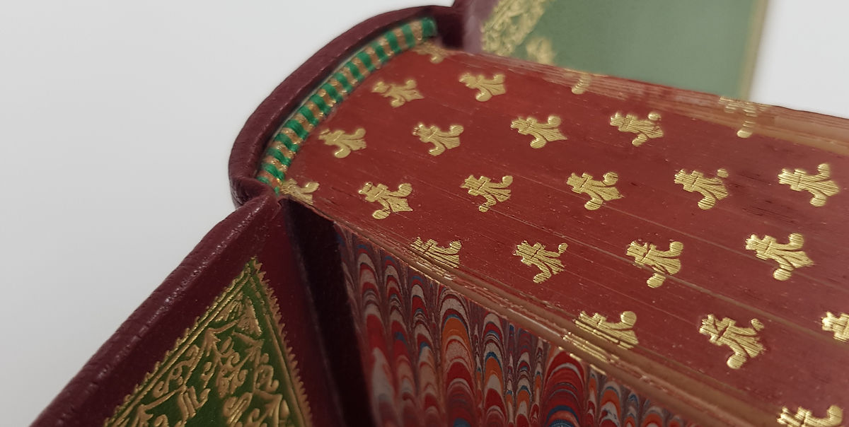 tranche de tête d'un livre tranche teintée reliure d'art feuille d'or fleur de lys semi page de garde en peau cuir vert tranchefile brodée à la main artisan relieur gabriel de sevin caen ifs